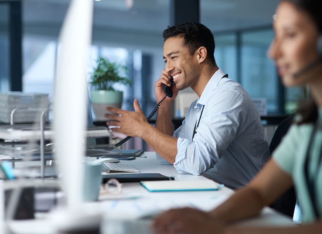 Contact - Cheerful Office Worker Speaking to a Client on the Phone